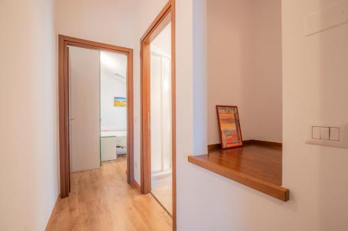 a hallway with a mirror and a wooden shelf at Valpolicella Homes Recioto Apartment in SantʼAmbrogio di Valpolicella
