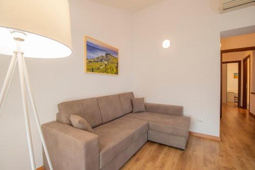 a living room with a couch and a lamp at Valpolicella Homes Recioto Apartment in SantʼAmbrogio di Valpolicella