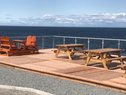two picnic tables and chairs on a deck of a cruise ship at Motel La Marina in Matane