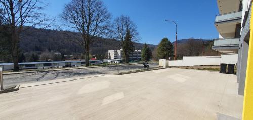 a large empty parking lot with a building and trees at Penthouse apartmán Minerál B-4 in Bardejovské Kúpele