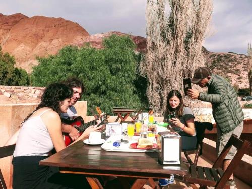a group of people sitting around a wooden table at La Valentina in Purmamarca
