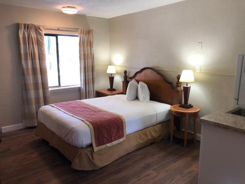 a hotel room with a bed and a window at Ocala Cove Motel in Ocala