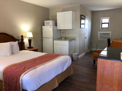 a hotel room with a bed and a kitchen at Ocala Cove Motel in Ocala