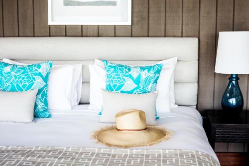 a hat sitting on top of a bed with pillows at Yacht Club Villas in Hamilton Island