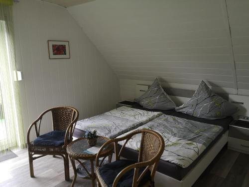 a bedroom with a bed with two chairs and a table at Gästehaus Spies in Bullay