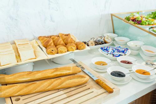 een tafel met brood en ander voedsel erop bij Yarra Ocean Suites Danang in Da Nang