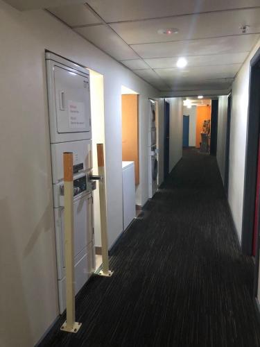 an empty hallway in an office with a refrigerator at Elizabeth Hostel in Melbourne