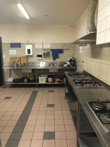 a kitchen with a stove top oven in a kitchen at Elizabeth Hostel in Melbourne