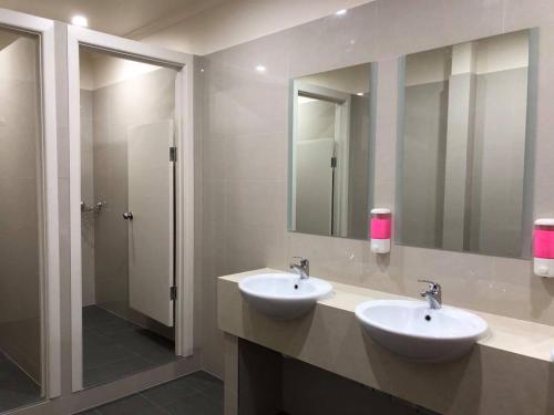 a bathroom with two sinks and a large mirror at Elizabeth Hostel in Melbourne