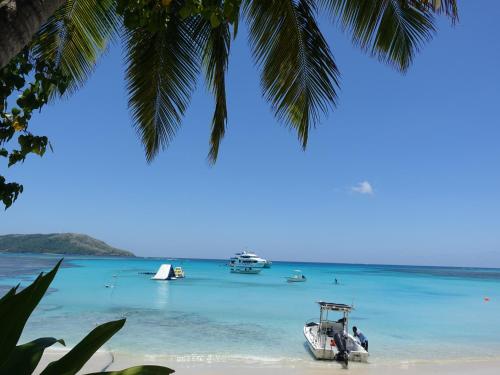 a boat on a beach with boats in the water at Blue Lagoon Beach Resort in Nacula Island