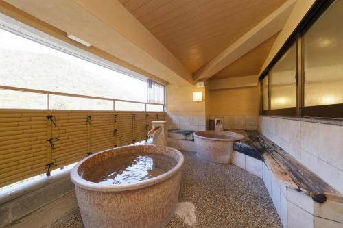 a large bathroom with two large tubs in it at Hakoneji Kaiun in Hakone