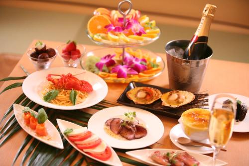 una mesa con platos de comida y una botella de vino en Hotel Lotus Iwatsuki (Adult Only), en Iwatsuki