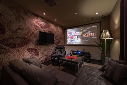 a living room with a couch and a projection screen at Hotel Lotus Iwatsuki (Adult Only) in Iwatsuki