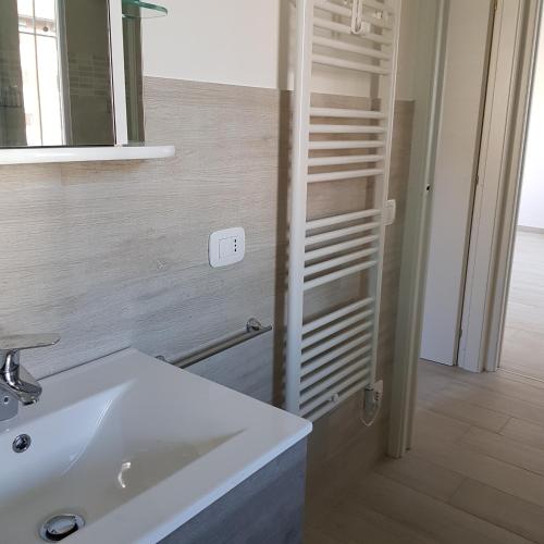 a bathroom with a white sink and a mirror at Pisogne new apartment in Pisogne