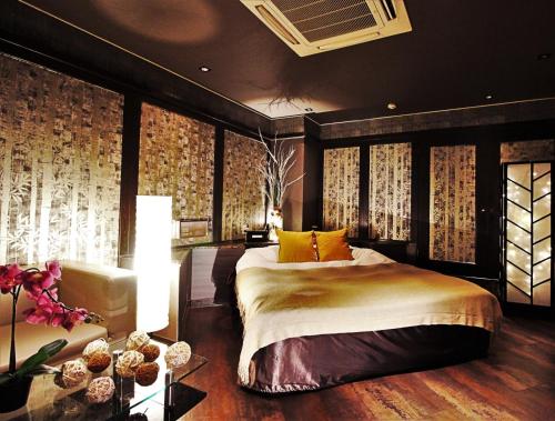 a bedroom with a bed and a table with flowers at HOTEL O2 -Adult Only- in Hirabari