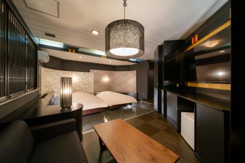 a bedroom with a bed and a table in a room at Royal Hotel Uohachi Bettei in Ogaki