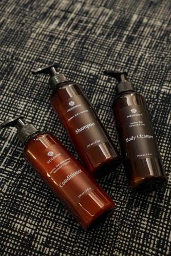a group of three hair products sitting on a bed at Kosenda Hotel in Jakarta
