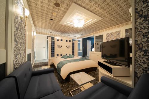 a bedroom with a bed and a flat screen tv at Royal Hotel Uohachi Bettei in Ogaki
