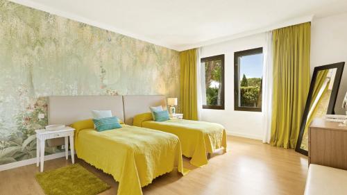 two beds in a room with yellow sheets at Villa Marina in Marbella
