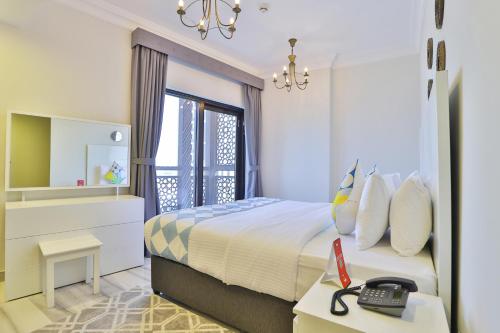 a bedroom with a bed and a desk with a phone at OYO 490 Home Marbella 2 BR in Dubai