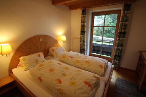 um pequeno quarto com uma cama e uma janela em Pension Christoph em Kramsach