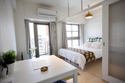 a small room with a bed and a table at Yakuin apartment in Fukuoka