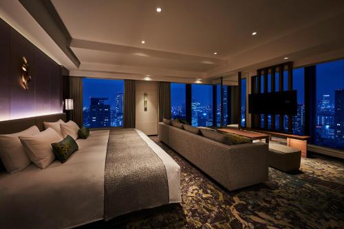 1 dormitorio con cama, sofá y TV en The Royal Park Hotel Iconic Osaka Midosuji, en Osaka