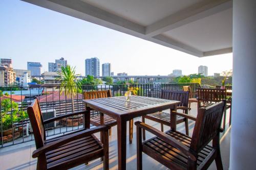 a wooden table and chairs on a balcony at Lily Hotel Bangkok in Bangkok