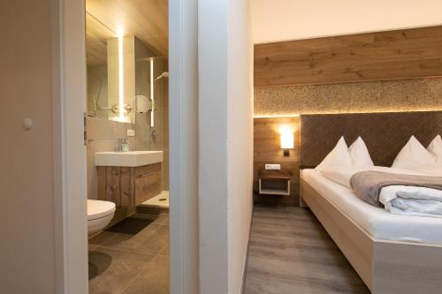 a bathroom with a bed and a sink and a toilet at Hotel am Wald in Bad Tölz