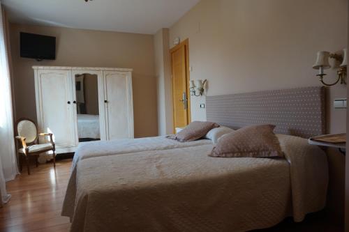 a bedroom with a bed and a tv on the wall at Arganzón Plaza in La Puebla de Arganzón