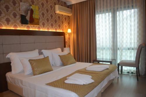 a bedroom with a large bed with towels on it at Kalif Hotel in Ayvalık