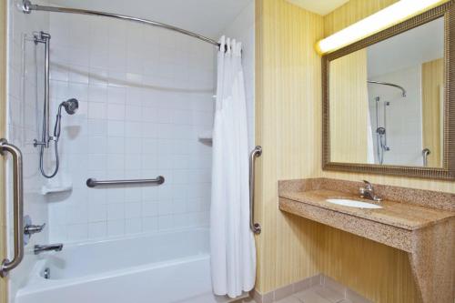 a bathroom with a tub and a sink and a shower at Holiday Inn Express Hotel & Suites Howell by IHG in Howell