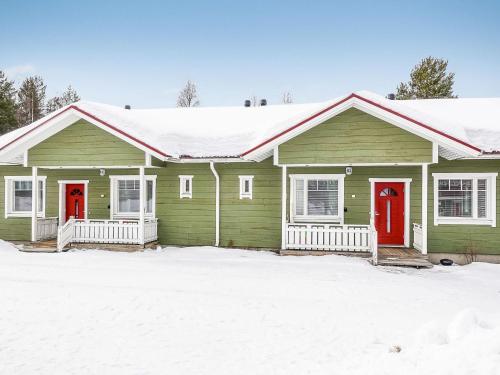 SaarenkyläにあるHoliday Home Huoneisto b1 by Interhomeの雪中の赤い扉のある緑の家