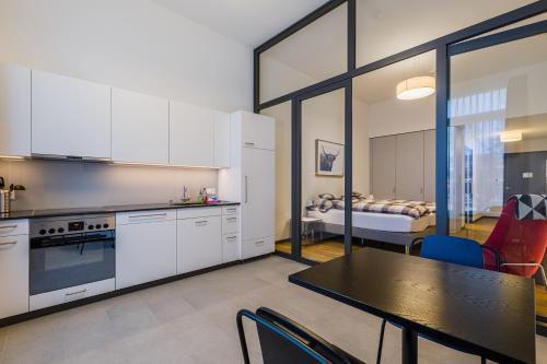 a kitchen with white cabinets and a table and a bedroom at Giesserei in Arbon