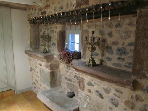 a stone room with a stone wall with a window at Domaine d'Armagnac in Bessuéjouls
