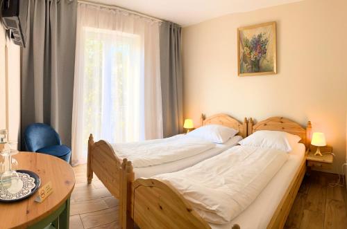 a bedroom with two beds and a table and a window at Arena Stadt München in Munich