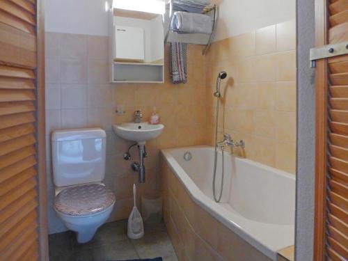 a bathroom with a toilet a sink and a bath tub at Holiday Home Chalet Guldeli by Interhome in Kandergrund
