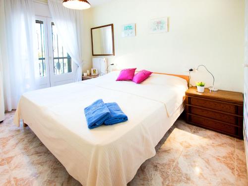 エンプリアブラバにあるHoliday Home Requesens canalのベッドルーム(紫色の枕が付いた大きな白いベッド付)