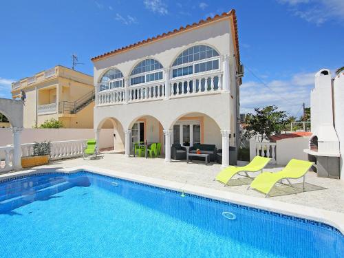 a villa with a swimming pool in front of a house at Holiday Home Requesens by Interhome in Empuriabrava