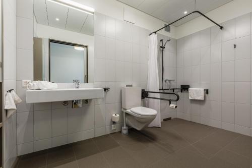 a white bathroom with a toilet and a sink at Giesserei in Arbon