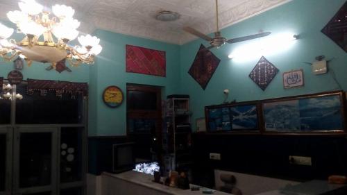 een woonkamer met blauwe muren en een kroonluchter bij Hotel Hill City Mingora Swat in Mām Derai
