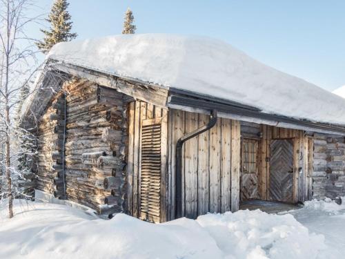 ein altes, schneebedecktes Blockhaus in der Unterkunft Holiday Home Nousujohde c1 by Interhome in Ruka