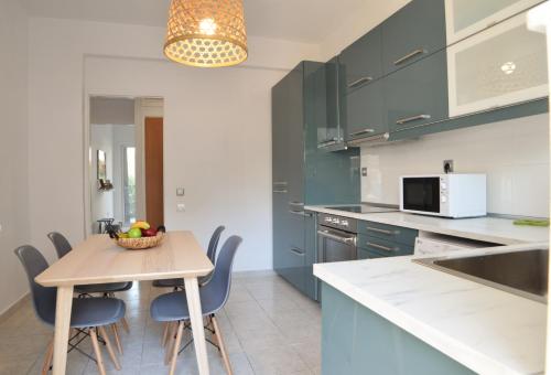 een keuken met blauwe kasten en een tafel en stoelen bij Popi's Place in Rhodos-stad