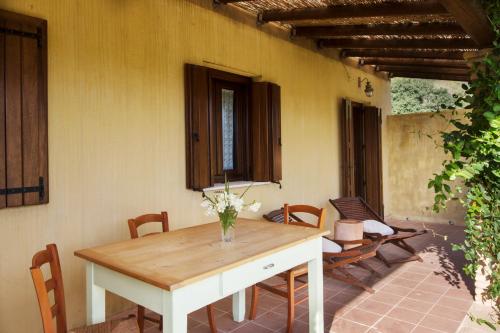 a dining room with a table and chairs on a patio at Terremesu a Castiadas Villasimius Costa Rei in Castiadas