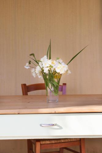 a vase of white flowers sitting on a table at Terremesu a Castiadas Villasimius Costa Rei in Castiadas