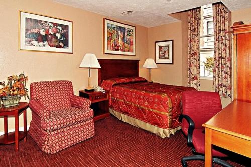 um quarto de hotel com uma cama e uma cadeira em Midtown Inn em Baltimore