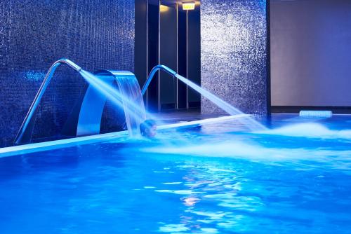 a person in a swimming pool with a water slide at RR Alvor Baía Resort in Alvor