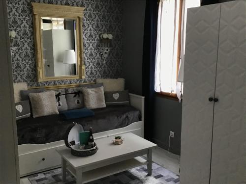 a bedroom with a bed with a mirror and a table at Appartement Médicis avec Garage in Honfleur