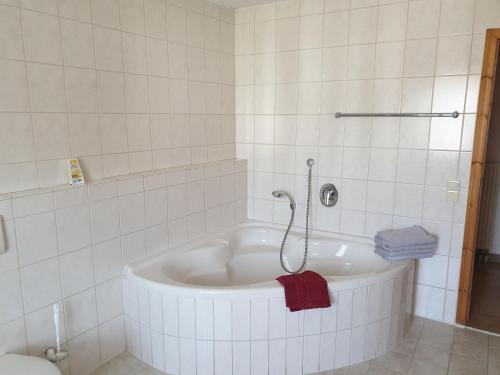 y baño con bañera blanca y toalla roja. en Ferienhof Murr, en Thurmansbang