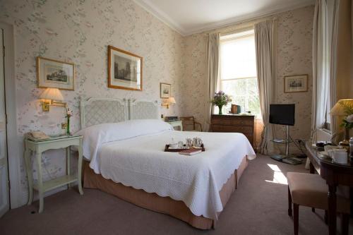 a bedroom with a white bed and a television at Middlethorpe Hall & Spa in York